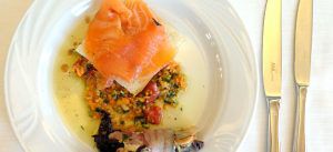 Carpaccio di salmone marinato agli agrumi con radicchio stufato e arrotolato da pancetta coppata e scamorza affumicata