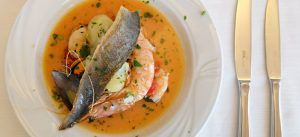 Branzino arrosto con patate e guazzetto di scampi vongole e cozze in padella